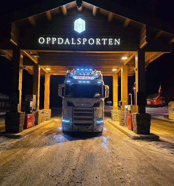 Hvit lastebil under Oppdalsporten om natten.